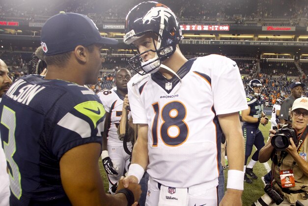 Aug 17, 2013; Seattle, WA, USA; Seattle Seahawks quarterback Russell Wilson (3) and Denver Broncos quarterback Peyton Manning (18) speak following a 40-10 preseason victory by the Seahawks at CenturyLink Field. Mandatory Credit: Joe Nicholson-USA TODAY Sports