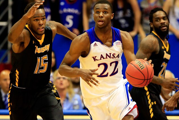 LAWRENCE, KS - NOVEMBER 22: Andrew Wiggins #22 of the Kansas Jayhawks drives upcourt on a fast break as Timajh Parker-Rivera #15 and Rafriel Guthrie #22 of the Towson Tigers chase during the game at Allen Fieldhouse on November 22, 2013 in Lawrence, Kansas. (Photo by Jamie Squire/Getty Images)