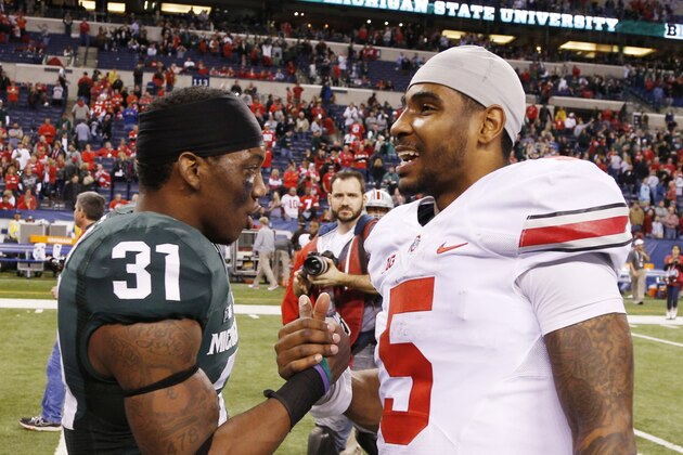 Dec 7, 2013; Indianapolis, IN, USA; Michigan State Spartans cornerback Darqueze Dennard (31) shakes with Ohio State Buckeyes quarterback Braxton Miller (5) after the Big 10 Championship game at Lucas Oil Stadium. Michigan State defeats Ohio State 34-24.  Mandatory Credit: Brian Spurlock-USA TODAY Sports