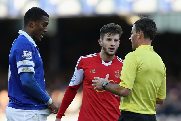 LIVERPOOL, ENGLAND - DECEMBER 29:  Adam Lallana of Southampton and Sylvain Distin of Everton are spoken to by Referee Mark Clattenburg during the Barclays Premier League match between Everton and Southampton at Goodison Park on December 29, 2013 in Liverpool, England.  (Photo by Clive Brunskill/Getty Images)