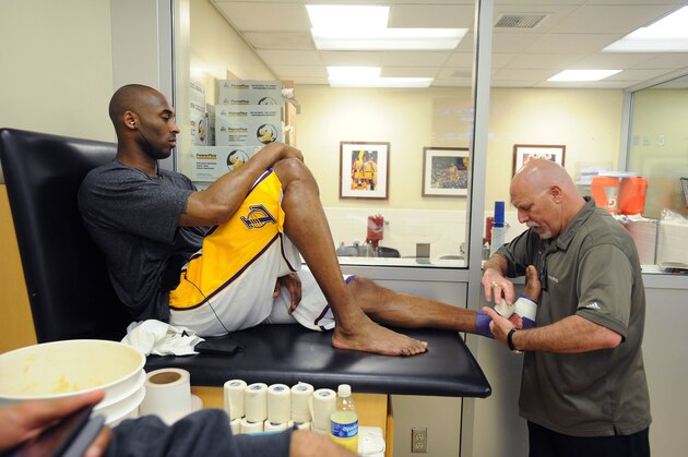 LOS ANGELES, CA - APRIL 22:  Kobe Bryant #24 of the Los Angeles Lakers has his ankle taped by head athletic trainer Gary Vitti before a game against the Oklahoma City Thunder at Staples Center on April 22, 2012 in Los Angeles, California. NOTE TO USER: User expressly acknowledges and agrees that, by downloading and/or using this Photograph, user is consenting to the terms and conditions of the Getty Images License Agreement. Mandatory Copyright Notice: Copyright 2012 NBAE (Photo by Andrew D. Bernstein/NBAE via Getty Images)