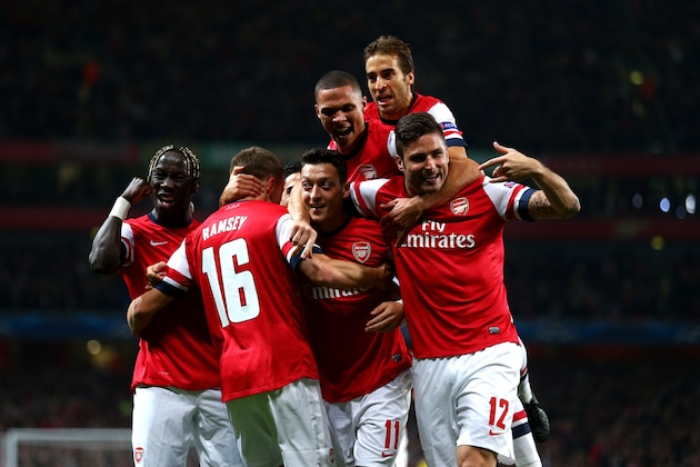 LONDON, ENGLAND - OCTOBER 01:  Mesut Oezil (C)of Arsenal is congratulated by teammates after scoring the opening goal during UEFA Champions League Group F match between Arsenal FC and SSC Napoli at Emirates Stadium on October 1, 2013 in London, England.  (Photo by Paul Gilham/Getty Images)