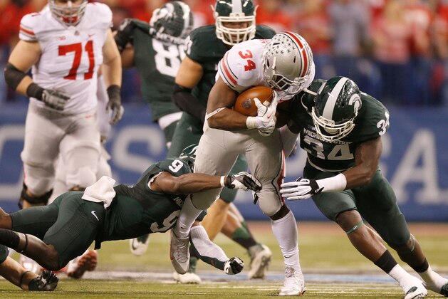 INDIANAPOLIS, IN - DECEMBER 07: Isaiah Lewis #9 and Taiwan Jones #34 of the Michigan State Spartans tackle Carlos Hyde #34 of the Ohio State Buckeyes during the Big 10 Conference Championship Game at Lucas Oil Stadium on December 7, 2013 in Indianapolis, Indiana.  (Photo by Gregory Shamus/Getty Images)