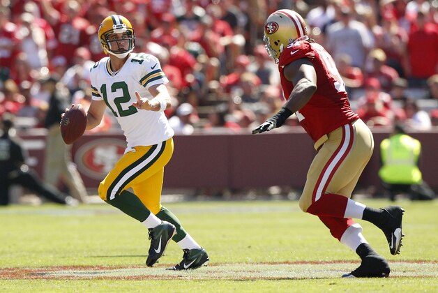 Sep 8, 2013; San Francisco, CA, USA; Green Bay Packers quarterback Aaron Rodgers (12) is chased by San Francisco 49ers defensive tackle Ray McDonald (91) in the second quarter at Candlestick Park. The 49ers defeated the Packers 34-28. Mandatory Credit: Cary Edmondson-USA TODAY Sports