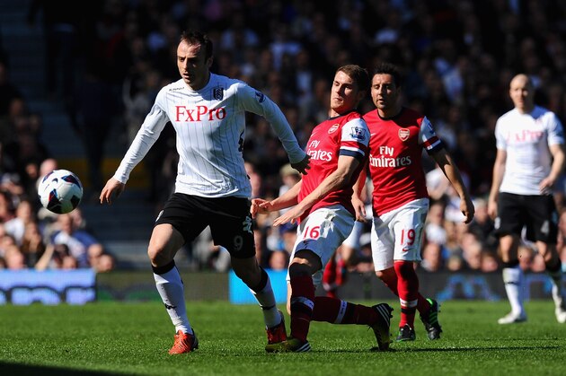 LONDON, ENGLAND - APRIL 20:  Dimitar Berbatov of Fulham and Aaron Ramsey of Arsenal tussle for the ball during the Barclays Premier League match between Fulham and Arsenal at Craven Cottage on April 20, 2013 in London, England.  (Photo by Mike Hewitt/Getty Images)