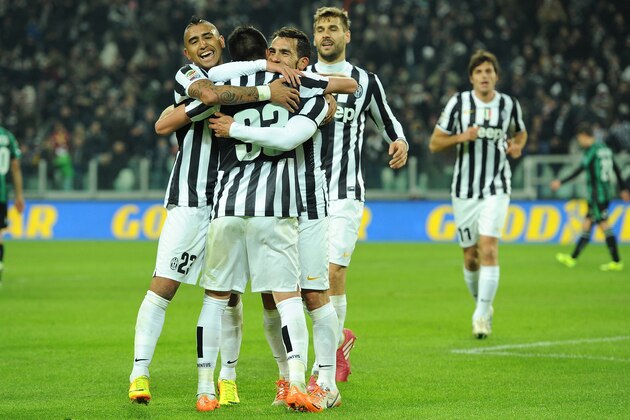 TURIN, ITALY - DECEMBER 15:  Carlos Tevez (R) of Juventus celebrates his third goal with team-mates Arturo Vidal (L) and Mauricio Isla (C) during the Serie A match between Juventus and US Sassuolo Calcio at Juventus Arena on December 15, 2013 in Turin, Italy.  (Photo by Valerio Pennicino/Getty Images)