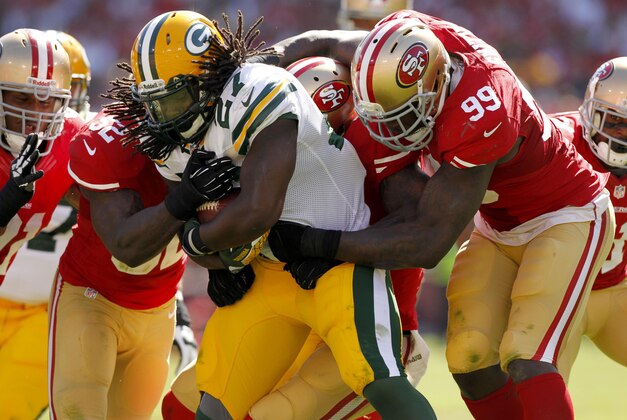 Sep 8, 2013; San Francisco, CA, USA; Green Bay Packers running back Eddie Lacy (27) is tackled by San Francisco 49ers linebacker Aldon Smith (99) and 49ers linebacker Patrick Willis (52) in the third quarter at Candlestick Park. The 49ers defeated the Packers 34-28. Mandatory Credit: Cary Edmondson-USA TODAY Sports