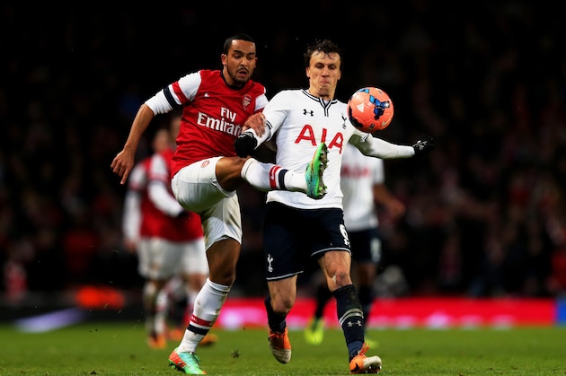 LONDON, ENGLAND - JANUARY 04:  Theo Walcott of Arsenal and Vlad Chiriches of Spurs compete for the ball during the Budweiser FA Cup match between Arsenal and Tottenham Hotspur at Emirates Stadium on January 4, 2014 in London, England.  (Photo by Clive Rose/Getty Images)
