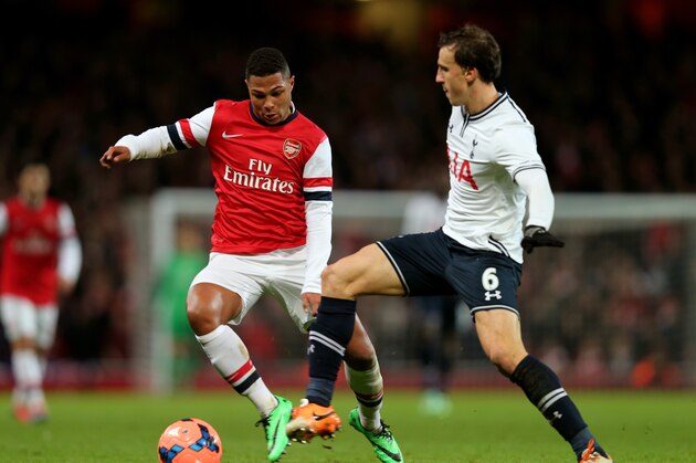 LONDON, ENGLAND - JANUARY 04:  Serge Gnabry of Arsenal and Vlad Chiriches of Spurs compete for the ball during the Budweiser FA Cup third round match between Arsenal and Tottenham Hotspur at Emirates Stadium on January 4, 2014 in London, England.  (Photo by Clive Rose/Getty Images)