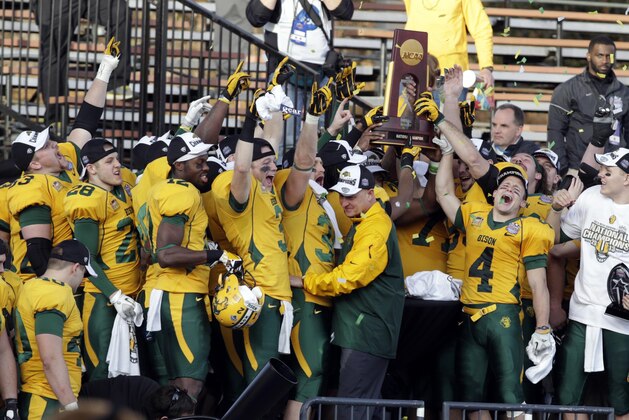 Jan 4, 2014; Frisco, TX, USA; Members of the North Dakota State Bison team and head coach Craig Bohl hold up the championship trophy after the division 1 championship game against the Towson Tigers at Toyota Stadium. North Dakota State beat Towson 35-7. Mandatory Credit: Tim Heitman-USA TODAY Sports