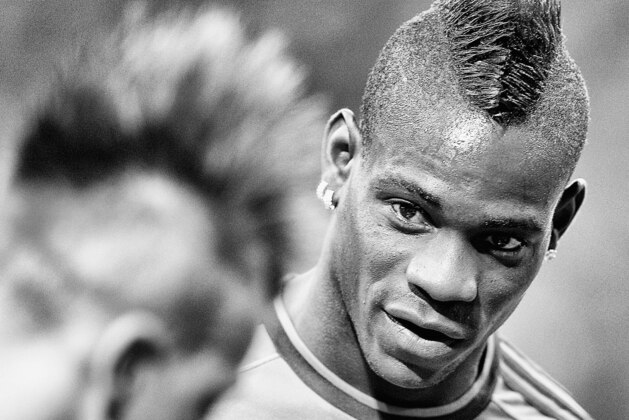 MILAN, ITALY - AUGUST 28:  (EDITORS NOTE: Image has been converted to black and white.) Mario Balotelli of AC Milan (R) before the UEFA Champions League Play-off Second Leg match between AC Milan v PSV Eindhoven at Stadio Giuseppe Meazza on August 28, 2013 in Milan, Italy.  (Photo by Claudio Villa/Getty Images)
