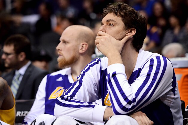 Dec 23, 2013; Phoenix, AZ, USA; Los Angeles Lakers center Pau Gasol (16) and center Chris Kaman (9) react on the bench in the second half against the Phoenix Suns at US Airways Center. The Suns won 117-90. Mandatory Credit: Jennifer Stewart-USA TODAY Sports