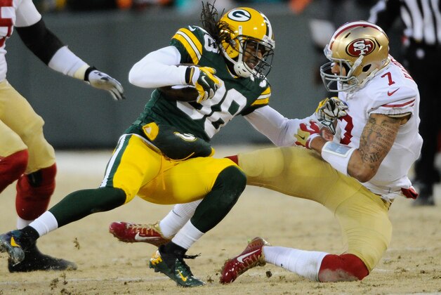 Jan 5, 2014; Green Bay, WI, USA;  Green Bay Packers cornerback Tramon Williams (38) is tackled by San Francisco 49ers quarterback Colin Kaepernick (7) after  intercepting a pass in the second quarter during the 2013 NFC wild card playoff football game at Lambeau Field. Mandatory Credit: Benny Sieu-USA TODAY Sports