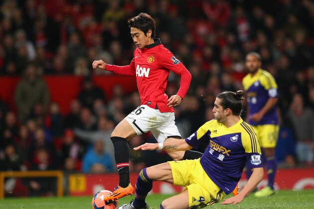 MANCHESTER, ENGLAND - JANUARY 05:  Chico Flores of Swansea City challenges Shinji Kagawa of Manchester United during the FA Cup with Budweiser Third round match between Manchester United and Swansea City at Old Trafford on January 5, 2014 in Manchester, England.  (Photo by Alex Livesey/Getty Images)