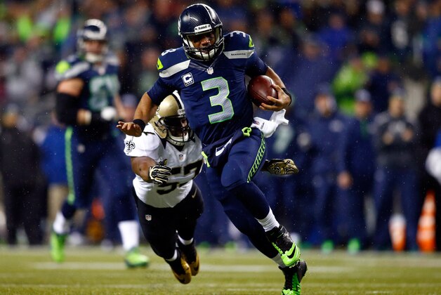 SEATTLE, WA - DECEMBER 02: Quarterback Russell Wilson #3 of the Seattle Seahawks runs with the ball as outside linebacker David Hawthorne #57 of the New Orleans Saints defends during a game at CenturyLink Field on December 2, 2013 in Seattle, Washington.  (Photo by Jonathan Ferrey/Getty Images)