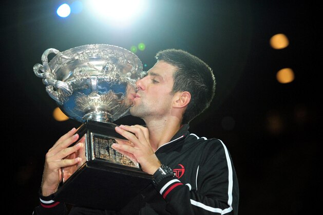 Jan 29, 2012; Melbourne, AUSTRALIA; Novak Djokovic (SRB) poses with the championship trophy after his match against Rafael Nadal (ESP) in the men's singles finals of the 2012 Australian Open at Melbourne Park.  Djokovic won 5-7, 6-4, 6-2, 6-7, 7-5. Mandatory Credit: Pierre Lahalle/Presse Sports via USA TODAY Sports