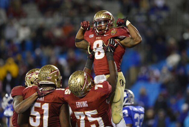 Dec 7, 2013; Charlotte, NC, USA; Florida State Seminoles offensive linesman Cameron Erving (75) lifts up running back Devonta Freeman (8) after Freeman's touchdown in the fourth quarter as offensive linesman Bobby Hart (51) looks on. The Seminoles defeated the Blue Devils 45-7 at Bank of America Stadium. Mandatory Credit: Bob Donnan-USA TODAY Sports