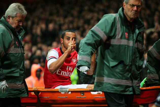 LONDON, ENGLAND - JANUARY 04:  The injured Theo Walcott of Arsenal makes a 2-0 gesture to the Tottenham fans as he is stretchered off the pitch during the Budweiser FA Cup third round match between Arsenal and Tottenham Hotspur at Emirates Stadium on January 4, 2014 in London, England.  (Photo by Clive Rose/Getty Images)