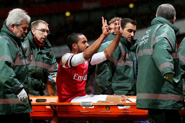 LONDON, ENGLAND - JANUARY 04:  The injured Theo Walcott of Arsenal makes a 2-0 gesture to the Tottenham fans as he is stretchered off the pitch during the Budweiser FA Cup third round match between Arsenal and Tottenham Hotspur at Emirates Stadium on January 4, 2014 in London, England.  (Photo by Clive Rose/Getty Images)