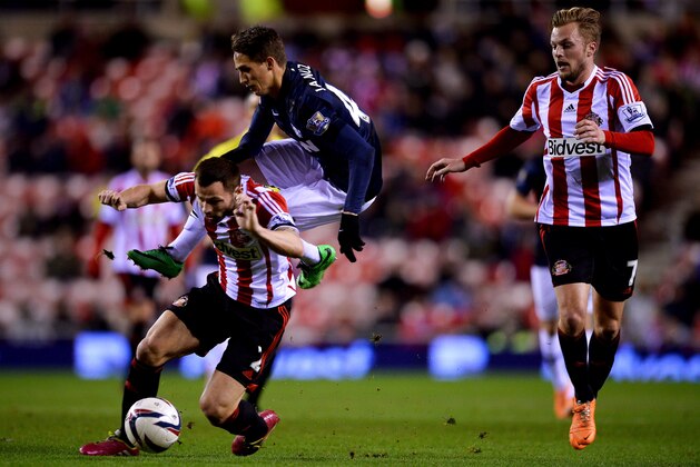 SUNDERLAND, ENGLAND - JANUARY 07:  Adnan Januzaj of Manchester United is challenged by Phil Bardsley of Sunderland as Sebastian Larsson of Sunderland (R) looks on during the Capital One Cup Semi-Final, first leg match between Sunderland and Manchester United at Stadium of Light on January 7, 2014 in Sunderland, England.  (Photo by Laurence Griffiths/Getty Images)