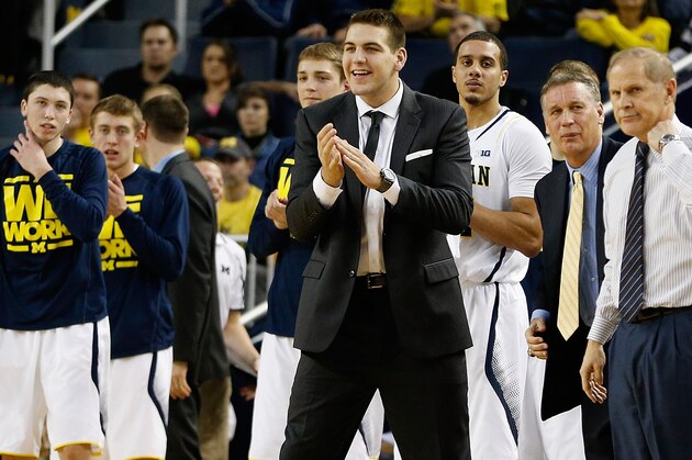 ANN ARBOR, MI - DECEMBER 28:  Mitch McGary (in black suit) of the Michigan Wolverines cheers on his team from the bench during a game against the Holy Cross Crusaders at Crisler Center on December 28, 2013 in Ann Arbor, Michigan. McGary is out of the lineup indefinitely after deciding to have surgery on his lower back, according to published reports. (Photo by Gregory Shamus/Getty Images)