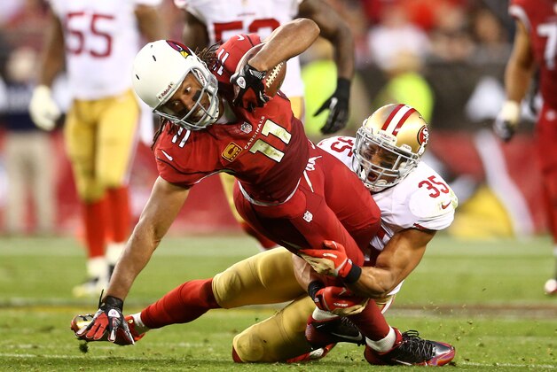 Dec 29, 2013; Phoenix, AZ, USA; Arizona Cardinals wide receiver Larry Fitzgerald (11) is tackled by San Francisco 49ers safety Eric Reid (35) in the fourth quarter at University of Phoenix Stadium. The 49ers defeated the Cardinals 23-20. Mandatory Credit: Mark J. Rebilas-USA TODAY Sports