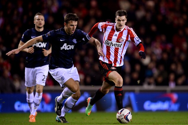 SUNDERLAND, ENGLAND - JANUARY 07:  Michael Carrick of Manchester United and Adam Johnson of Sunderland battle for the ball during the Capital One Cup Semi-Final, first leg match between Sunderland and Manchester United at Stadium of Light on January 7, 2014 in Sunderland, England.  (Photo by Laurence Griffiths/Getty Images)