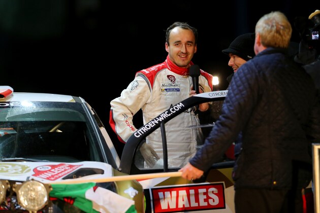 LLANDUDNO, WALES - NOVEMBER 14:  Robert Kubica of Poland is interviewed during the ceremonial start of the FIA World Rally Championship Great Britain on November 14, 2013 in Conwy, Wales.  (Photo by Clive Rose/Getty Images)