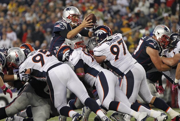 Pats 7, 2012; Foxboro, Massachusetts, USA; New England Patriots quarterback Tom Brady (12) goes over the pile to score a touchdown against the Denver Broncos during the third quarter at Gillette Stadium.  Mandatory Credit: Greg M. Cooper-USA TODAY Sports