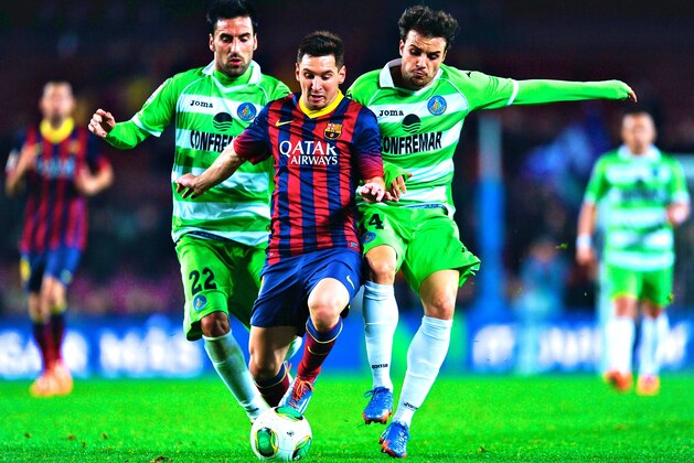 BARCELONA, SPAIN - JANUARY 08:  Lionel Messi of FC Barcelona duels for the ball with Mehdi Lacen of Getafe CF during the Copa del Rey round of 16 first leg match between FC Barcelona and Getafe CF at Camp Nou on January 8, 2014 in Barcelona, Spain.  (Photo by David Ramos/Getty Images)