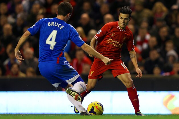 LIVERPOOL, ENGLAND - JANUARY 01:  Philippe Coutinho of Liverpool competes with Alex Bruce of Hull City for the ball during the Barclays Premier League match between Liverpool and Hull City at Anfield on January 1, 2014 in Liverpool, England.  (Photo by Clive Brunskill/Getty Images)
