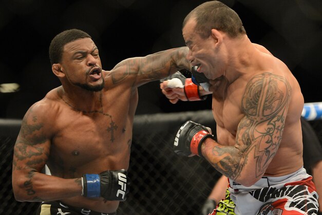 Dec 28, 2013; Las Vegas, NV, USA;    Gleison Tibau (red gloves) and Michael Johnson (blue gloves) during their UFC Featherweight Bout at the MGM Grand Garden Arena. Johnson won the fight. Mandatory Credit: Jayne Kamin-Oncea-USA TODAY Sports