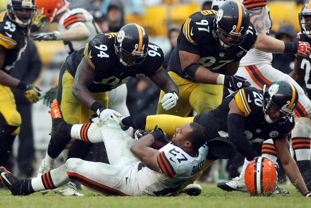 Dec 29, 2013; Pittsburgh, PA, USA; Cleveland Browns running back Edwin Baker (27) has his helmet knocked off as he is hit by Pittsburgh Steelers linebacker Lawrence Timmons (94) , defensive end Cameron Heyward (97) and safety Will Allen (20) in the second half at Heinz Field. The Steelers won the game, 20-7. Mandatory Credit: Jason Bridge-USA TODAY Sports