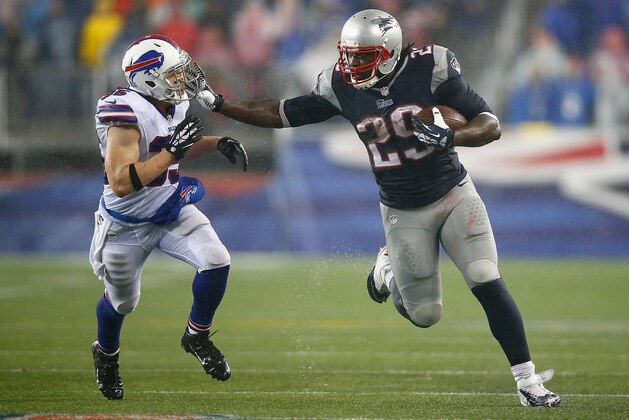 FOXBORO, MA - DECEMBER 29: LeGarrette Blount #29 of the New England Patriots stiff arms Jim Leonhard #35 of the Buffalo Bills on his way to a touchdown in the fourth quarter during the game at Gillette Stadium on December 29, 2013 in Foxboro, Massachusetts.  (Photo by Jared Wickerham/Getty Images)