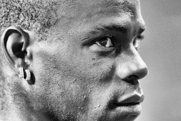 MILAN, ITALY - AUGUST 28:  (EDITORS NOTE: Image has been converted to black and white.) Mario Balotelli of AC Milan during the UEFA Champions League Play-off Second Leg match between AC Milan v PSV Eindhoven at Stadio Giuseppe Meazza on August 28, 2013 in Milan, Italy.  (Photo by Claudio Villa/Getty Images)