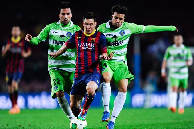 BARCELONA, SPAIN - JANUARY 08:  Lionel Messi of FC Barcelona duels for the ball with Juan Rodriguez (L) and Pedro Leon of Getafe CF during the Copa del Rey round of 16 first leg match between FC Barcelona and Getafe CF at Camp Nou on January 8, 2014 in Barcelona, Spain.  (Photo by David Ramos/Getty Images)