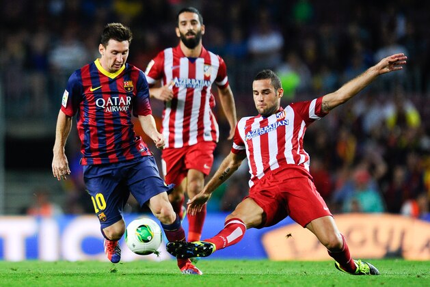 BARCELONA, SPAIN - AUGUST 28:  Lionel Messi (L) of FC Barcelona is challenged by Mario Suarez of Atletico de Madrid during the Spanish Super Cup second leg match between FC Barcelona and Atletico de Madrid at Nou Camp on August 28, 2013 in Barcelona, Spain.  (Photo by David Ramos/Getty Images)