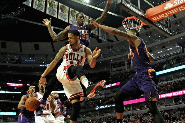 CHICAGO, IL - JANUARY 07: D.J. Augustin #14 of the Chicago Bulls passes the ball behind to Jimmy Butler #10 as Archie Goodwin #20 and Marcus Morris #15 (R) of the Phoenix Suns defend at the United Center on January 7, 2014 in Chicago, Illinois. The Bulls defeated the Suns 92-87. NOTE TO USER: User expressly acknowledges and agrees that, by downloading and or using this photograph, User is consenting to the terms and conditions of the Getty Images License Agreement. (Photo by Jonathan Daniel/Getty Images)