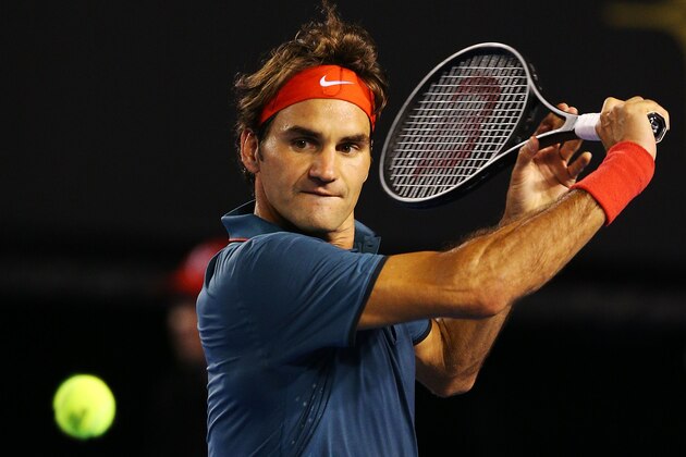 MELBOURNE, AUSTRALIA - JANUARY 08:  Roger Federer of Switzerland hits a backhand in his match against Jo Wilfried Tsonga of Francce during the Roger Federer Charity Match at Melbourne Park on January 8, 2014 in Melbourne, Australia.  (Photo by Michael Dodge/Getty Images)