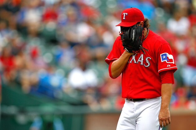 ARLINGTON, TX - SEPTEMBER 28:  Derek Holland #45 of the Texas Rangers looks down after pitching during a game against the Los Angeles Angels of Anaheim at Rangers Ballpark in Arlington on September 28, 2013 in Arlington, Texas.  (Photo by Sarah Glenn/Getty Images)