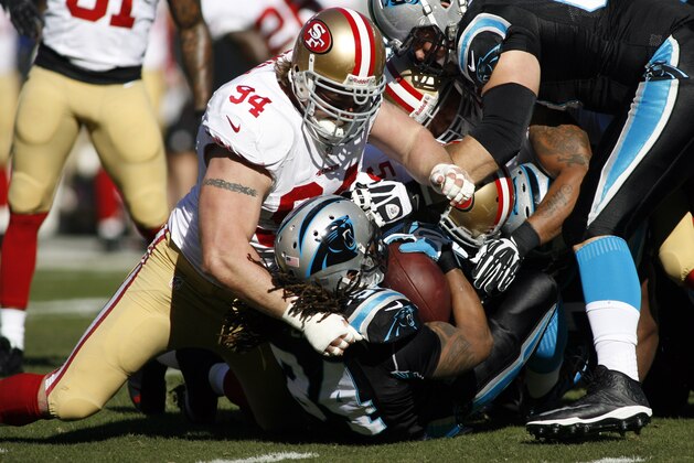 Jan 12, 2014; Charlotte, NC, USA; San Francisco 49ers defensive end Justin Smith (94) tackles Carolina Panthers running back DeAngelo Williams (34) during the first quarter of the 2013 NFC divisional playoff football game at Bank of America Stadium. Mandatory Credit: Jeremy Brevard-USA TODAY Sports