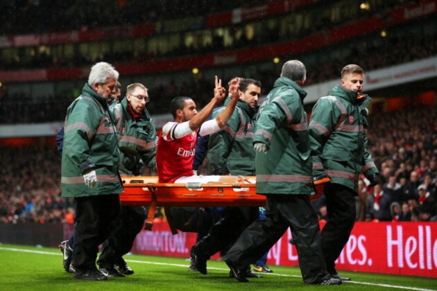 LONDON, ENGLAND - JANUARY 04:  The injured Theo Walcott of Arsenal makes a 2-0 gesture to the Tottenham fans as he is stretchered off the pitch during the Budweiser FA Cup third round match between Arsenal and Tottenham Hotspur at Emirates Stadium on January 4, 2014 in London, England.  (Photo by Clive Rose/Getty Images)