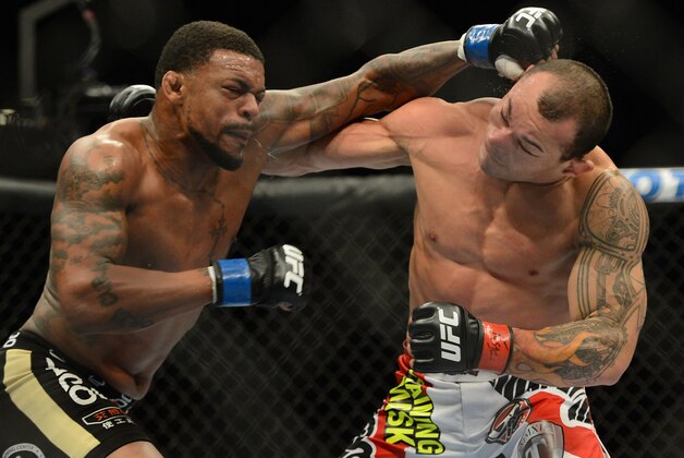 Dec 28, 2013; Las Vegas, NV, USA;    Gleison Tibau (red gloves) and Michael Johnson (blue gloves) during their UFC Featherweight Bout at the MGM Grand Garden Arena. Johnson won the fight. Mandatory Credit: Jayne Kamin-Oncea-USA TODAY Sports