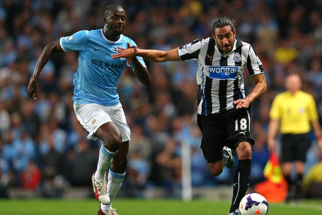 MANCHESTER, ENGLAND - AUGUST 19:  Jonas Gutierrez of Newcastle United holds off a challenge from Yaya Toure of Manchester City during the Barclays Premier League match between Manchester City and Newcastle United at the Etihad Stadium on August 19, 2013 in Manchester, England.  (Photo by Alex Livesey/Getty Images)