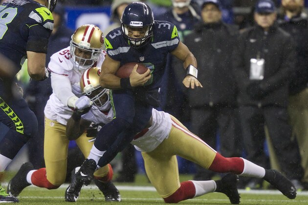 SEATTLE, WA - DECEMBER 23: Russell Wilson #3 of the Seattle Seahawks escapes the tackle of Aldon Smith #99 and Patrick Willis #52 of the Seattle Seahawks during a game at CenturyLink Field on December 23, 2012 in Seattle, Washington.  (Photo by Stephen Brashear/Getty Images)