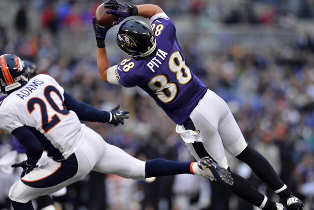 Dec 16 2012; Baltimore, MD, USA; Baltimore Ravens tight end Dennis Pitta (88) brings in a touchdown reception as he is defended by Denver Broncos strong safety Mike Adams (20) at M&T Bank Stadium.  The Broncos defeated the Ravens 34-17. Mandatory Credit: Ron Chenoy-USA TODAY Sports