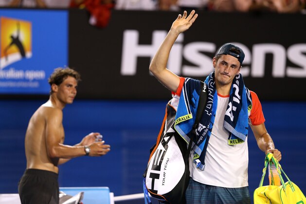 MELBOURNE, AUSTRALIA - JANUARY 14:  Bernard Tomic of Australia leaves the court as Rafael Nadal of Spain claps, after Tomic retired from their first round match during day two of the 2014 Australian Open at Melbourne Park on January 14, 2014 in Melbourne, Australia.  (Photo by Clive Brunskill/Getty Images)