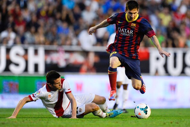MADRID, SPAIN - SEPTEMBER 21:  Lionel Messi of FC Barcelona duels for the ball with Saul Niguez of Rayo Vallecano during the La Liga match between Rayo Vallecano de Madrid and FC Barcelona at Estadio Teresa Rivero on September 21, 2013 in Madrid, Spain.  (Photo by David Ramos/Getty Images)