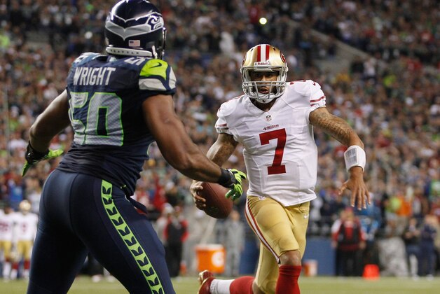 SEATTLE, WA - SEPTEMBER 15:  Quarterback Colin Kaepernick #7 of the San Francisco 49ers rushes against outside linebacker K.J. Wright #50 of the Seattle Seahawks at CenturyLink Field on September 15, 2013 in Seattle, Washington.  (Photo by Otto Greule Jr/Getty Images)