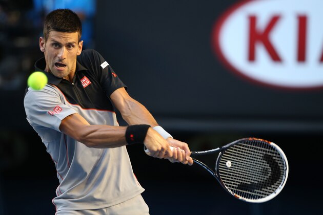 MELBOURNE, AUSTRALIA - JANUARY 13:  Novak Djokovic of Serbia plays a backhand in his first round match against Lukas Lacko of Slovakia during day one of the 2014 Australian Open at Melbourne Park on January 13, 2014 in Melbourne, Australia.  (Photo by Clive Brunskill/Getty Images)